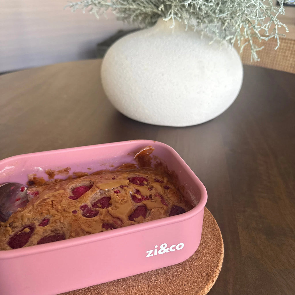 zi&co Silicone Rectangle Lunchbox in pink, filled with raspberry peanut butter baked oats