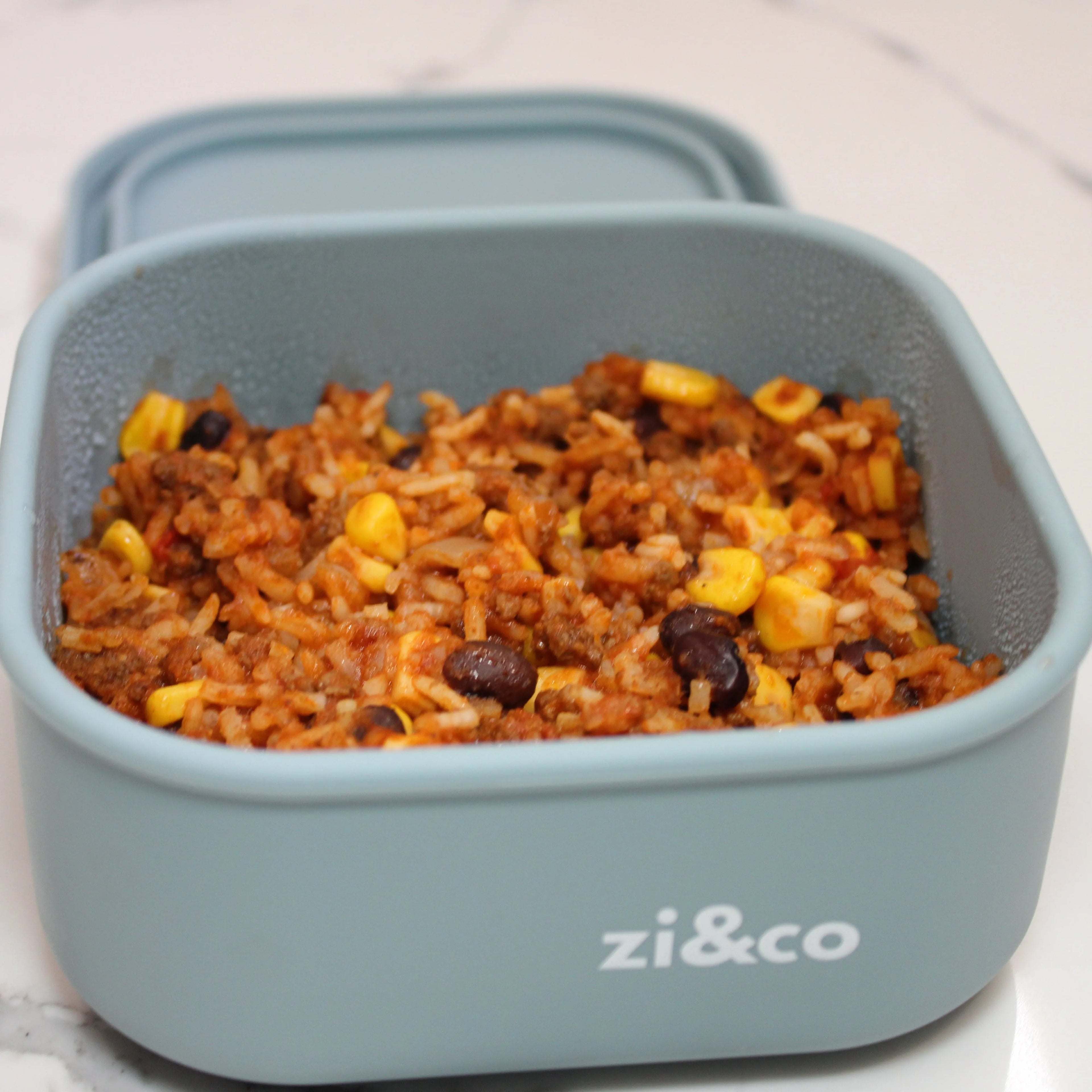 zi&co Silicone Square Lunchbox in sage blue-grey, filled with taco rice, beans and corn